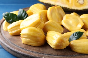 Delicious exotic jackfruit bulbs on wooden board, closeup