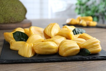 Fresh exotic jackfruit bulbs on wooden table