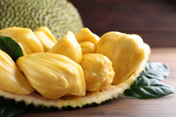 Fresh exotic jackfruit bulbs on wooden table, closeup