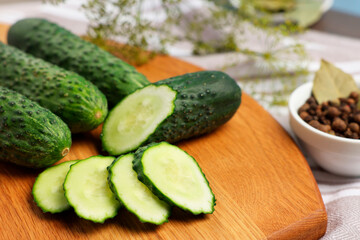 Fresh whole and cut cucumbers on table, closeup