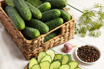 Fresh green cucumbers and spices on white wooden table, closeup