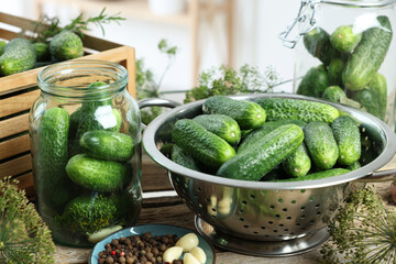 Fresh cucumbers, dill and spices on wooden table, closeup. Preparation for pickling