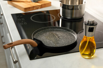 Frying pan with oil on cooktop in kitchen