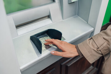 Woman entering pin code on atm keyboard