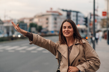 Elegant woman hailing a taxi cab on a city street