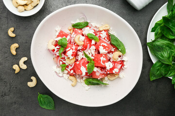 Tasty salad with watermelon, feta cheese and basil on black table, flat lay