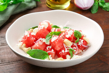 Tasty salad with watermelon, feta cheese and basil on wooden table
