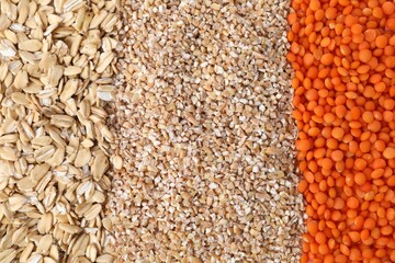 Red lentils, wheat groats and oat flakes as background, top view