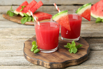 Tasty watermelon drink in glasses, fresh fruit and mint on wooden table