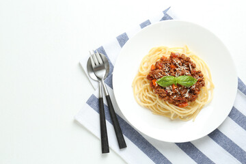 Delicious pasta bolognese and cutlery on white table, flat lay. Space for text