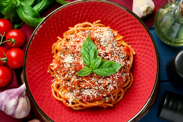 Delicious pasta bolognese with basil served on blue wooden table, top view