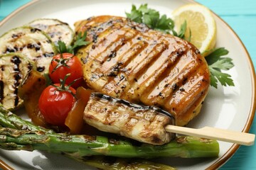 Delicious grilled vegetables and chicken breast on table, closeup