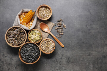 Different types of seeds and legumes on grey table, flat lay. Space for text