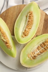 Fresh cut honeydew melon on white wooden table, top view