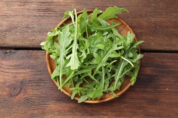 Fresh green arugula leaves on wooden table, top view