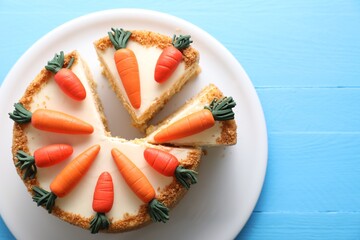 Plate with delicious carrot cake on blue wooden table, top view. Space for text