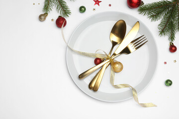 Christmas table setting with plate, cutlery and festive decor on white background, flat lay. Space for text