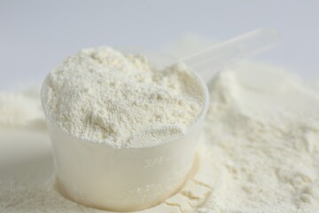 Protein powder and scoop on white background, closeup