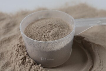 Pile of protein powder and scoop, closeup
