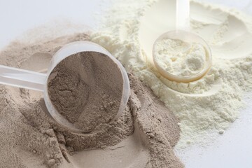 Protein powders and scoops on white background