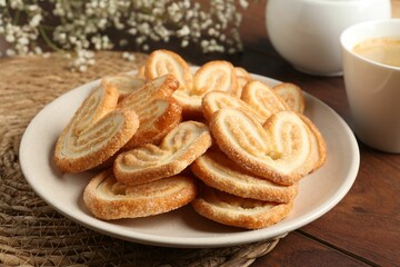 Naklejka premium Delicious palmier cookies with coffee on wooden table