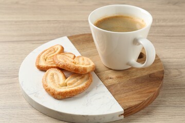 Delicious palmier cookies with coffee on wooden table