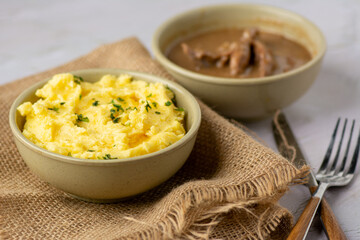 Close up image of Mashed potatoes on a fabric served with chicken sauce on a white background