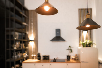 Modern minimalist kitchen interior with pendant lights illuminating wooden countertop at day time