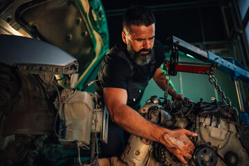 Mechanic performing car engine maintenance using a wrench