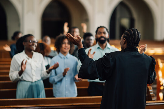 African american preacher leading congregation in prayer