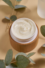 Bamboo jars with bamboo screw lid. Skincare concept on beige background with dry plants. Natural cosmetic concept for face body care