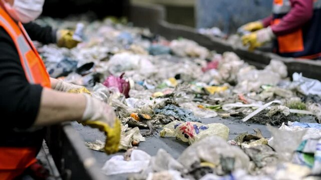 This video shows workers sorting household waste on a conveyor belt, separating recyclables from non-recyclables. The facility processes organic waste into compost and produces organic fertilizer.