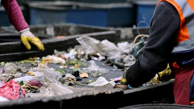 This video shows workers sorting household waste on a conveyor belt, separating recyclables from non-recyclables. The facility processes organic waste into compost and produces organic fertilizer.