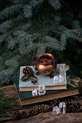 witch cauldron, minerals and spell witch books in forest, natural background. Magic Crystal Ritual....