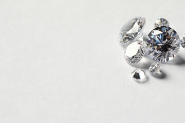 Many beautiful shiny diamonds on white background. Space for text