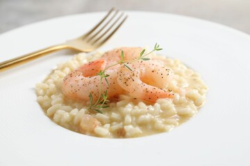 Delicious risotto with shrimps and cheese on plate, closeup
