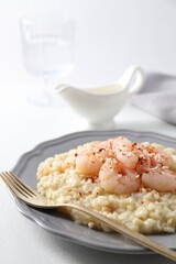 Delicious risotto with shrimps and cheese on white table, closeup