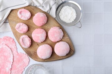 Tasty homemade mochi on white tiled table, top view. Space for text