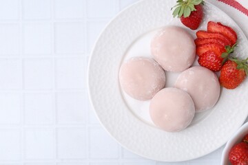 Delicious mochi and strawberries on white tiled table, top view. Space for text