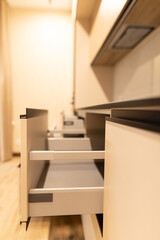 Exploring modern kitchen design with open drawers showcasing sleek interior details and renovation elegance in an inviting apartment space