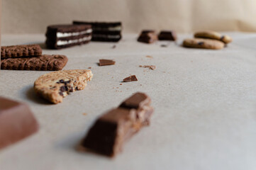 Restos o sobras de golosinas con trozos de galletas y chocolates esparcidos sobre papel estraza o kraft. 