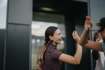 A group of international business people share a joyful moment outdoors in an urban city setting,...
