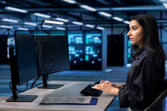 Software developer in server hub checking recovery plan, monitoring data center energy consumption. Indian woman in server room making sure sensors are functioning optimally, doing routine disk checks - Powered by Adobe