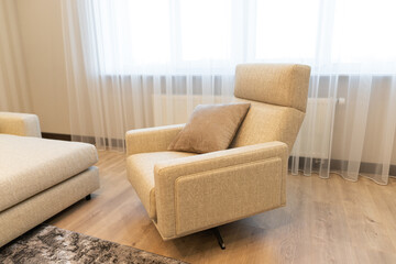 Modern apartment interior featuring a cozy recliner and soft textures in a bright, elegant space