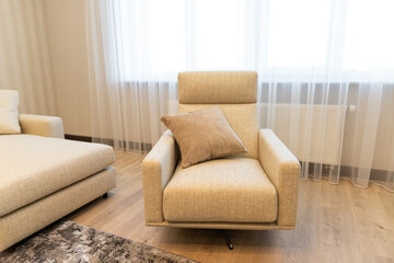 Modern apartment interior featuring a cozy armchair with soft lighting in a serene space designed for relaxation and comfort