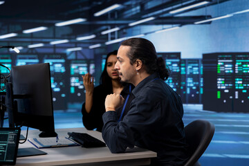 Technicians reconfiguring server room facility to optimize it for data processing requirements of...