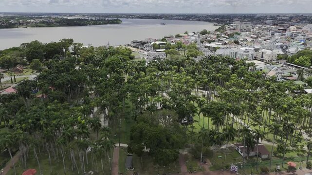 Drone flies over Waka Pasi and Palmtree Garden toward the Suriname River in Paramaribo, Suriname