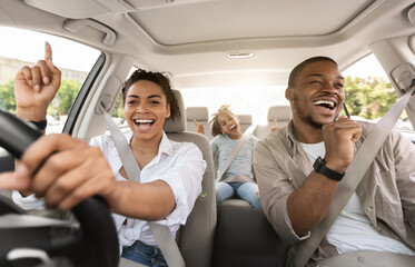 Cheerful Black Family Singing Riding New Car Having Fun Enjoying Road Trip On Vacation. Parents And...