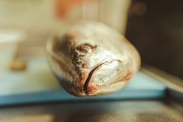 A raw fish is placed on a board, ready for filleting. Great for food blogs, seafood menus, or chef...