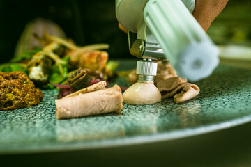 A close-up of a chef garnishing a dish. Perfect for cooking classes, gourmet restaurant promotions, or food styling tutorials.